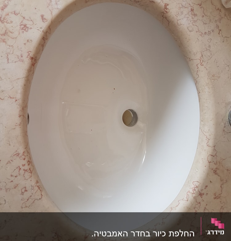כיור עגול על משטח שיש עם ורידים אדומים